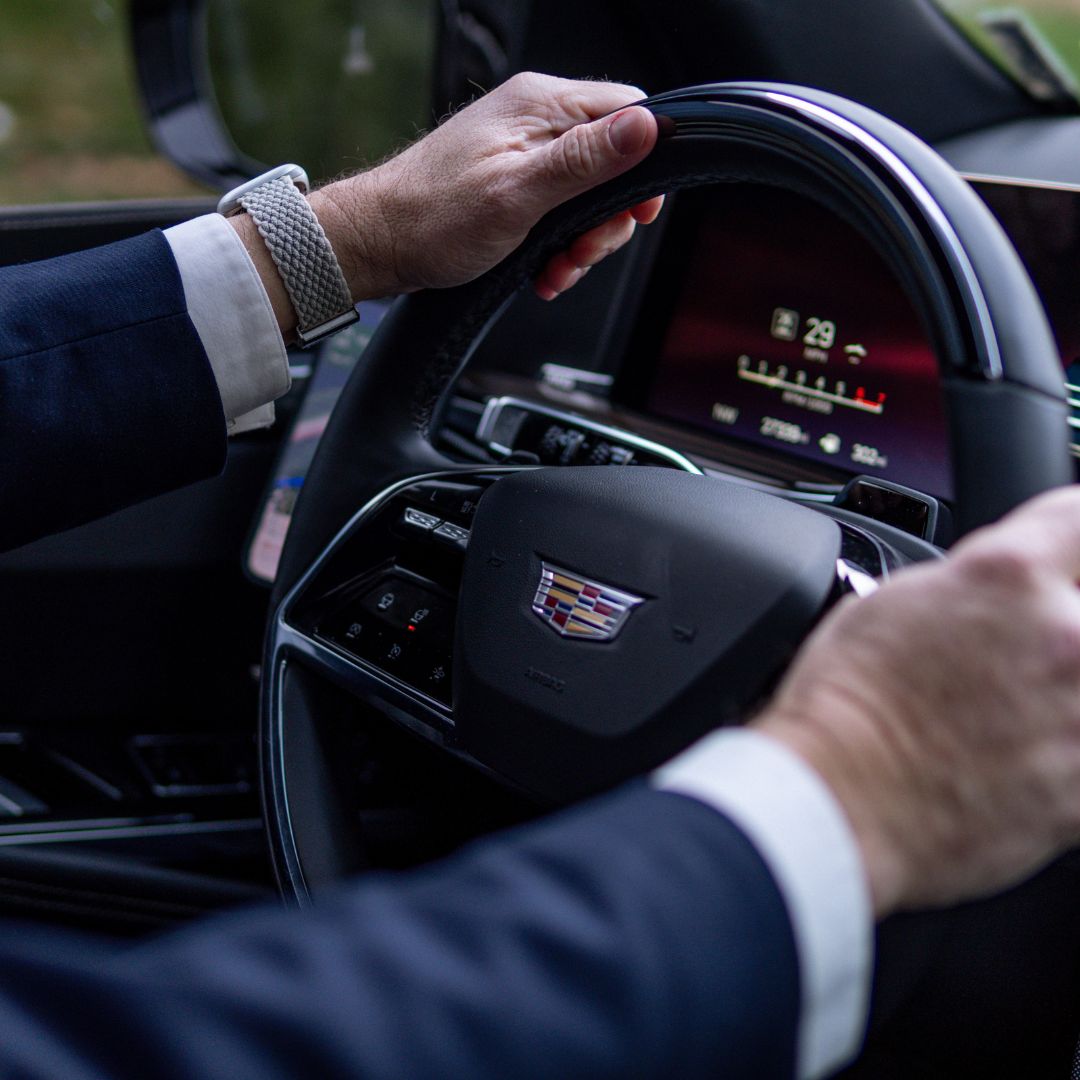 Professional URVIP chauffeur driving luxury Cadillac in Boston — executive car service