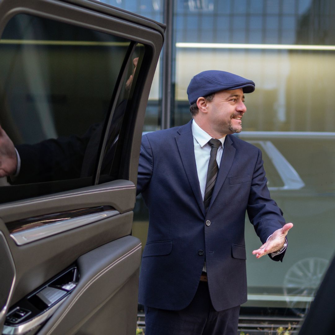 Professional URVIP chauffeur opening Cadillac Escalade door for Boston client